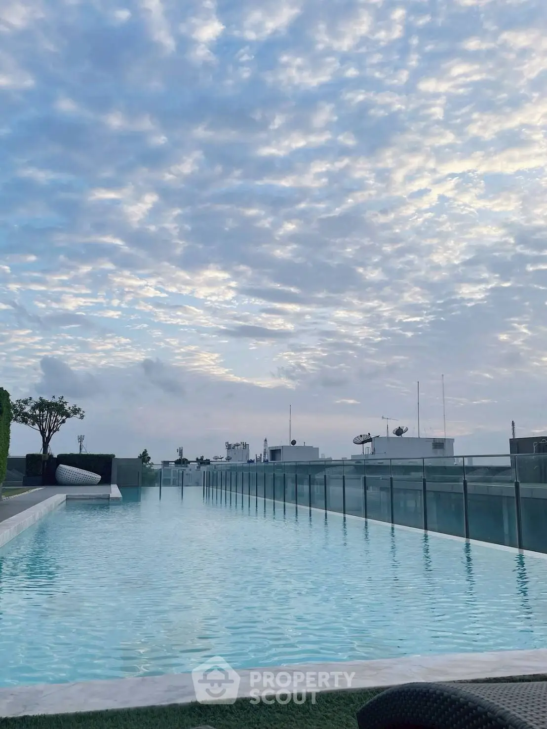 Stunning rooftop pool with panoramic city views under a beautiful sky.