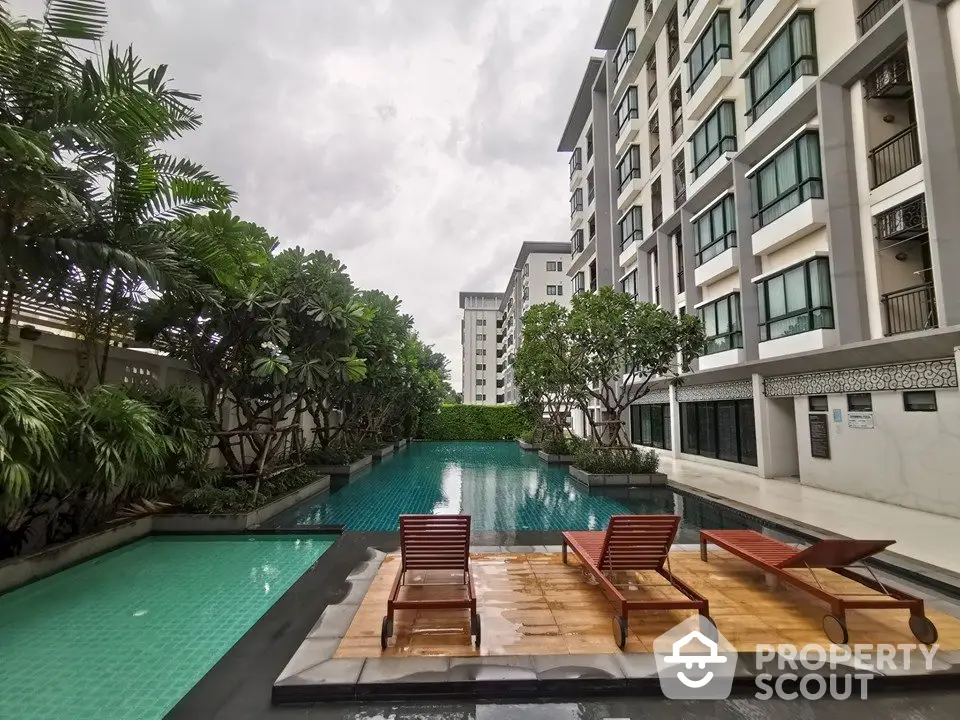 Luxurious condominium with serene poolside view and lush greenery