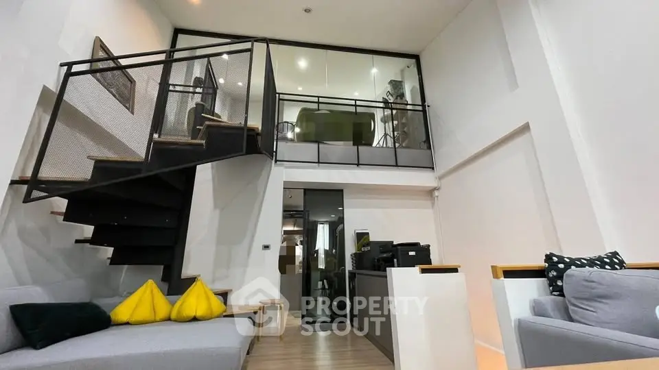 Modern loft-style living room with mezzanine and sleek staircase