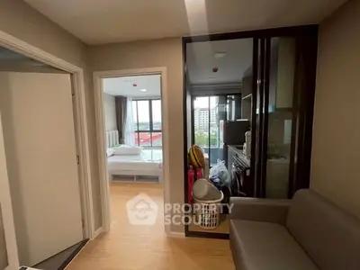Modern apartment interior with open layout, featuring a cozy living area and a glimpse of the bedroom.