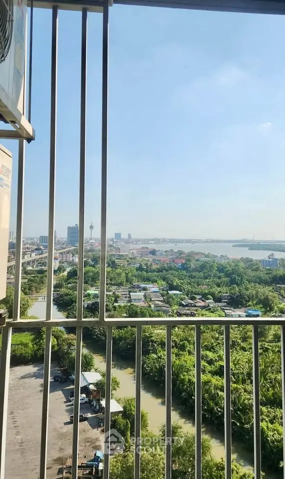 Stunning high-rise balcony view overlooking lush greenery and cityscape, perfect for urban living enthusiasts.
