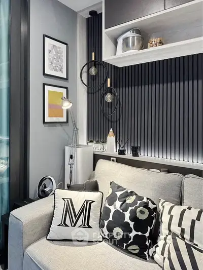 Stylish modern living room with cozy sofa and decorative pillows, featuring elegant wall art and ambient lighting.