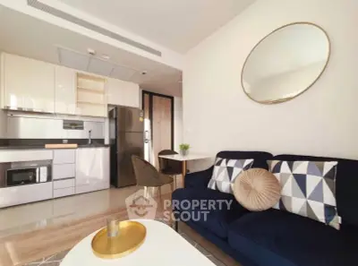 Modern living room with stylish kitchen, featuring sleek appliances and elegant decor.