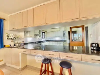 Spacious kitchen with granite countertops and breakfast bar in modern home