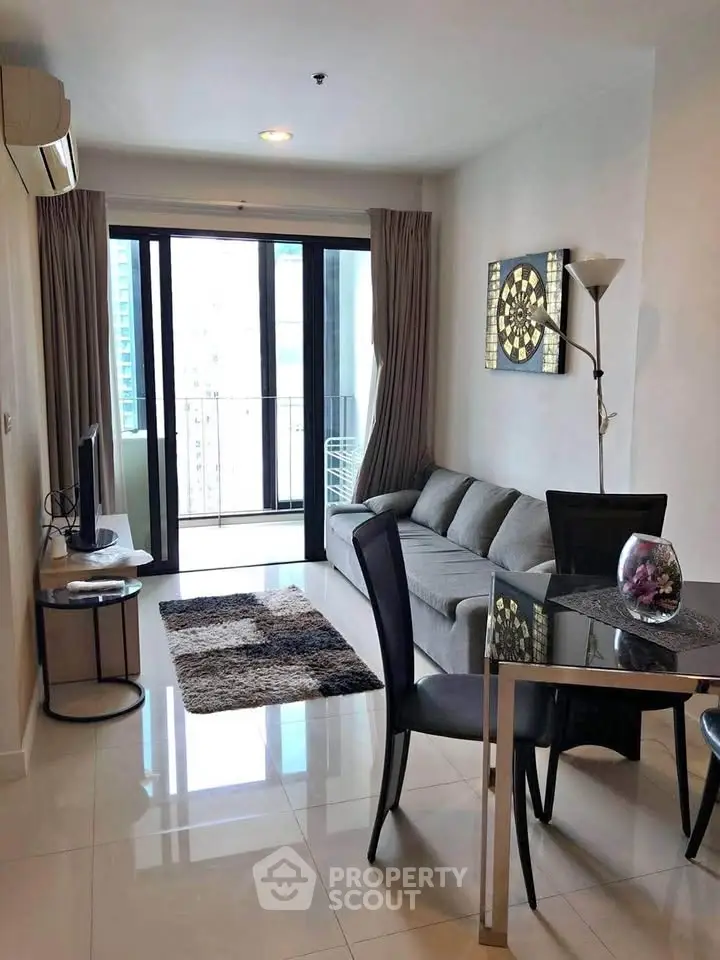 Modern living room with balcony view, sleek furniture, and elegant decor in a high-rise apartment.