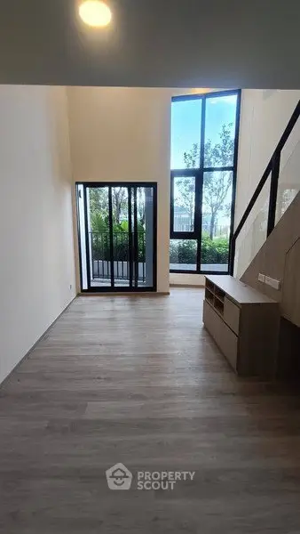 Spacious modern living room with large windows and balcony access