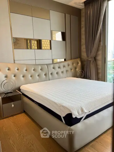 Luxurious bedroom with elegant decor and large windows offering natural light.