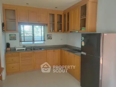 Spacious kitchen with wooden cabinets and modern appliances in a bright home.
