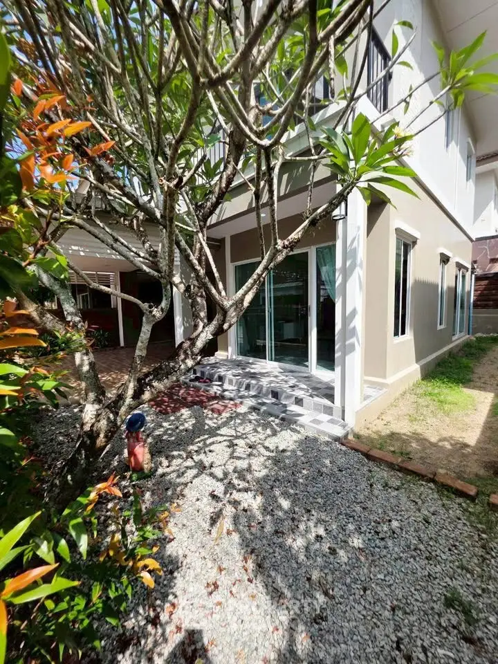 Charming two-story home with lush garden and inviting entrance, perfect for family living.