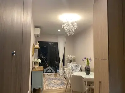 Elegant living room with chandelier and city view, featuring cozy dining area and stylish decor.