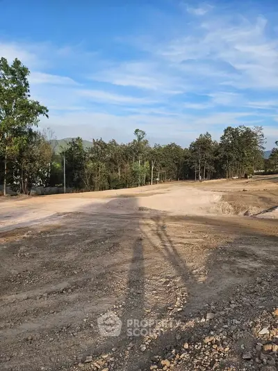 Expansive land plot with clear skies and lush greenery, ideal for development opportunities.