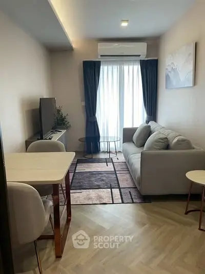 Modern living room with stylish decor and natural light, featuring a cozy sofa and dining area.