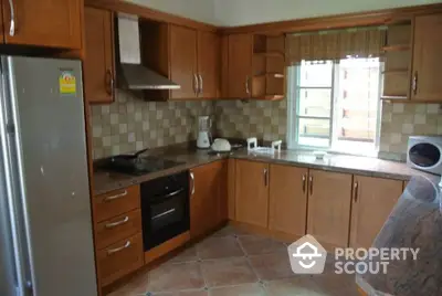 Spacious kitchen with wooden cabinets and modern appliances in a cozy home setting.