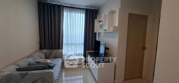 Modern living room with sleek furniture and large window for natural light.