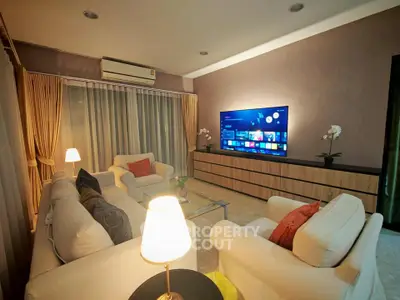 Elegant living room with modern decor, featuring cozy sofas, ambient lighting, and a large flat-screen TV.
