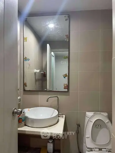 Modern bathroom with stylish sink and mirror, featuring cute decorative stickers.