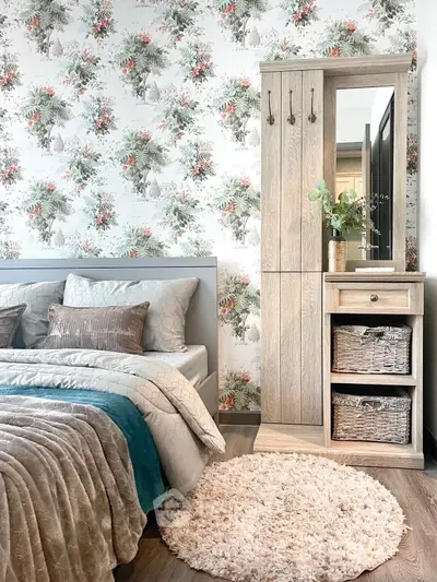 Charming bedroom with floral wallpaper, cozy bedding, and stylish wooden wardrobe for a serene retreat.