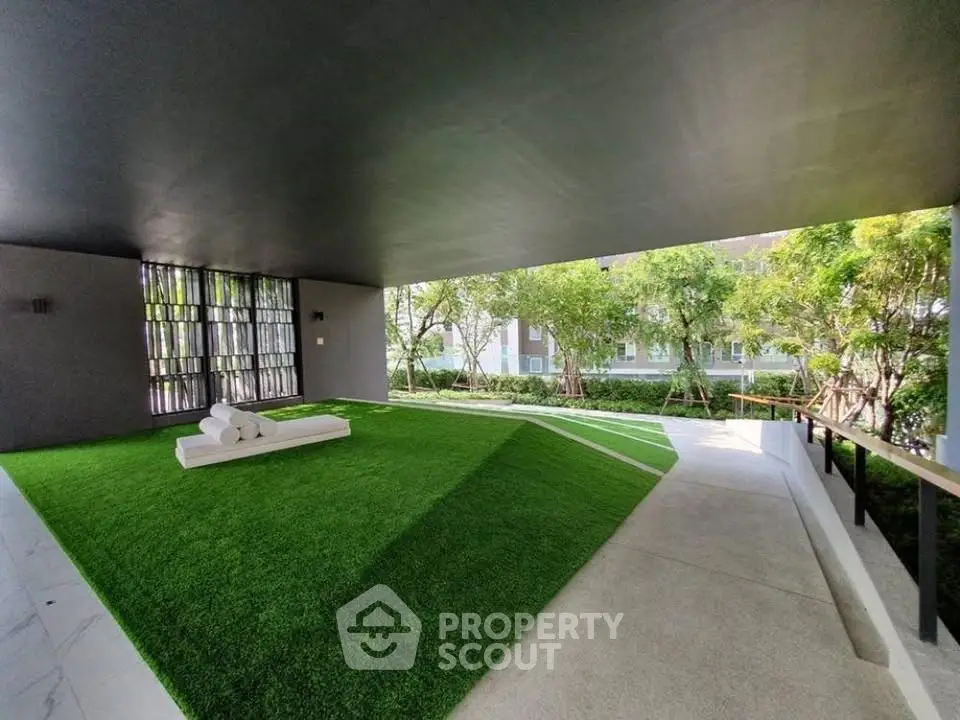 Modern building entrance with lush green landscaping and sleek design