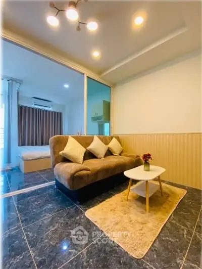 Modern living room with cozy sofa and stylish decor adjacent to a bedroom.