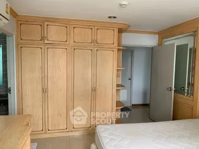 Spacious bedroom with built-in wooden wardrobe and cozy ambiance