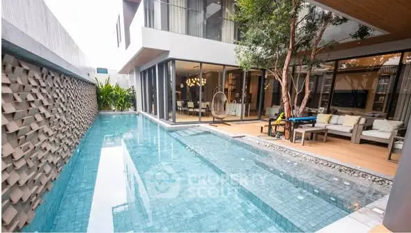 Luxurious modern home with private pool and stylish outdoor seating area.