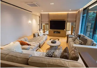 Luxurious modern living room with plush sofas and large TV, perfect for relaxation and entertainment.