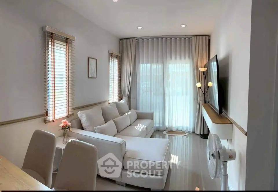 Chic modern living room with cozy sectional sofa and large TV, perfect for relaxation and entertainment.