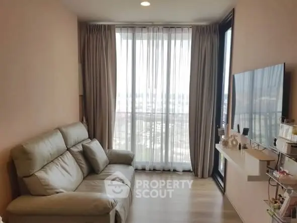 Modern living room with large window and comfortable sofa in high-rise apartment