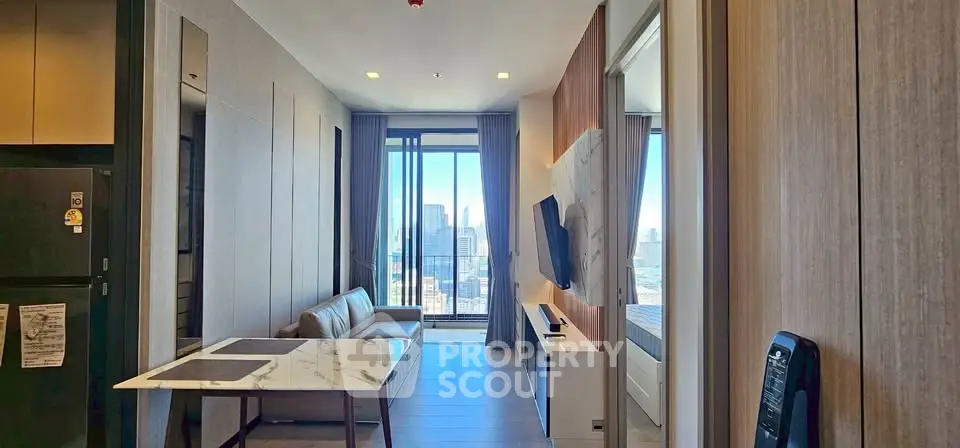 Modern living room with city view, sleek furniture, and open layout in high-rise apartment.