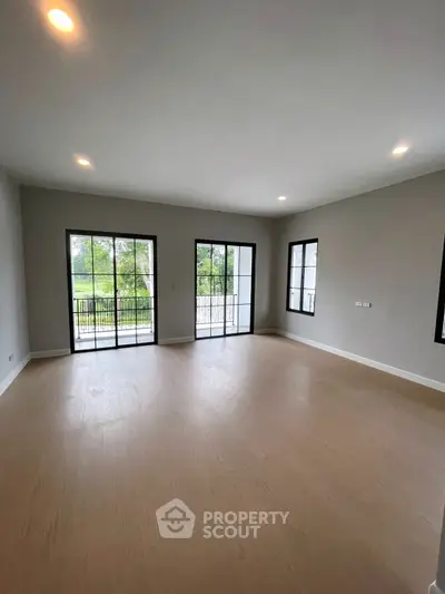 Spacious empty living room with large windows and balcony view