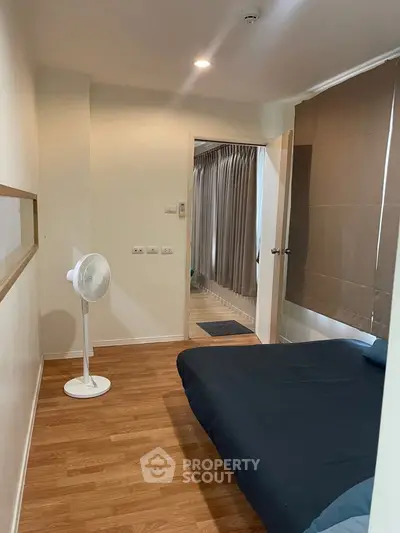 Cozy bedroom with wooden flooring and modern decor in a stylish apartment.
