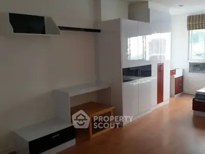 Modern bedroom with sleek white furniture and wooden flooring