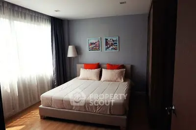 Cozy bedroom with natural light and stylish decor, perfect for relaxation.