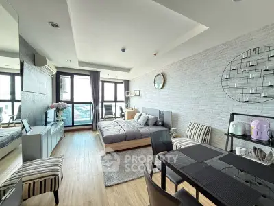Modern studio apartment with stylish decor and large windows offering natural light and city views.