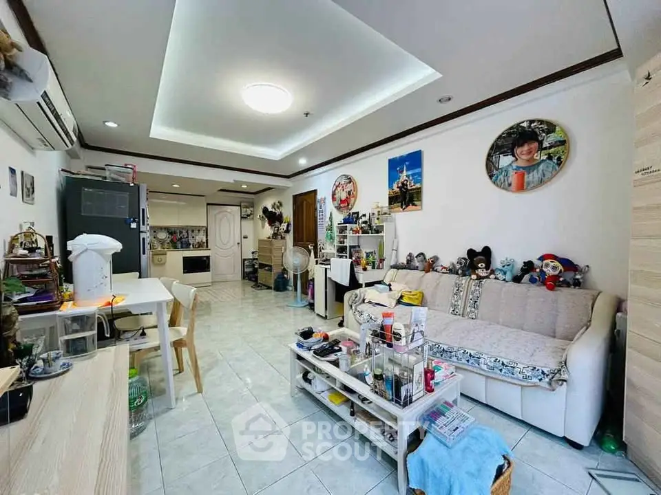 Spacious living room with cozy decor and modern lighting in a well-lit apartment.