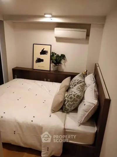 Cozy bedroom with modern decor and air conditioning unit, perfect for relaxation.