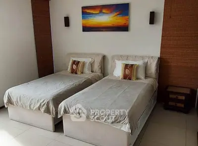 Cozy twin bedroom with modern decor and sunset artwork