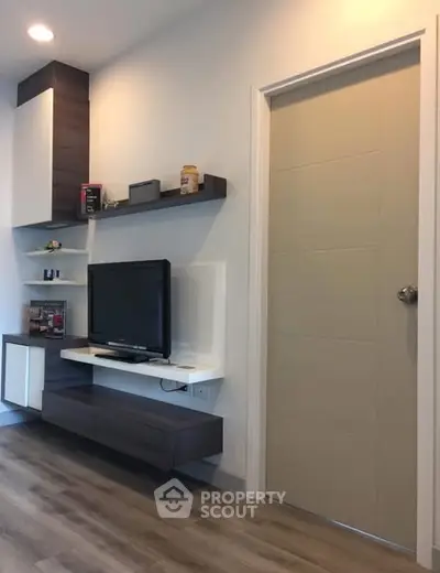 Modern living room with sleek TV unit and wooden flooring