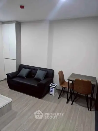 Modern living room with sleek sofa and dining set in a stylish apartment.