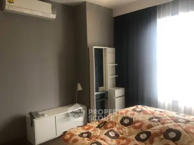 Cozy bedroom with modern decor and natural light, featuring air conditioning and stylish bedding.