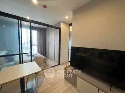 Modern studio apartment with glass partition and sleek wooden flooring