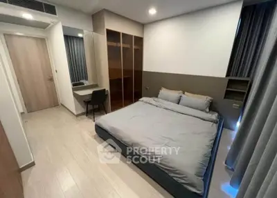 Modern bedroom with sleek design, featuring a comfortable bed, built-in wardrobe, and stylish desk area.