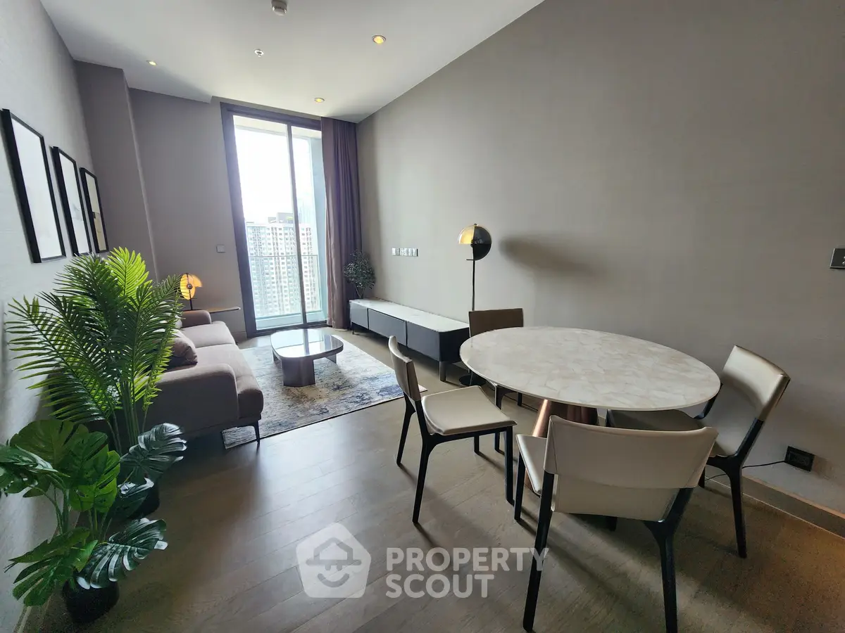 Modern living room with dining area and city view, featuring stylish furniture and natural light.