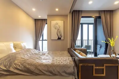 Luxurious bedroom with elegant decor and balcony access in modern apartment.