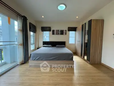 Spacious bedroom with modern decor and large windows for natural light