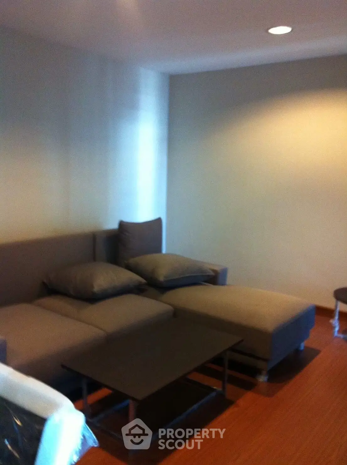 Modern living room with cozy sectional sofa and sleek coffee table, perfect for relaxation.