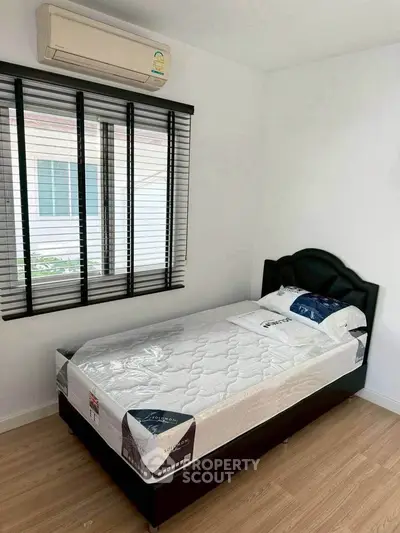 Cozy bedroom with single bed and air conditioning, perfect for a minimalist lifestyle.