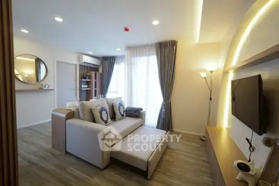 Modern living room with stylish decor and natural light, featuring a cozy sofa and sleek TV setup.