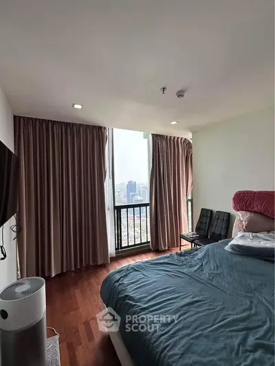 Spacious bedroom with city view, featuring large windows and elegant curtains, perfect for urban living.