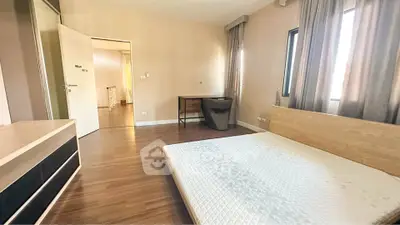 Spacious bedroom with modern furnishings and natural light in a stylish apartment.